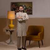 Arsalan Iqbal Beige Classic Chikankari Kurta Pyjama man wearing a beige full-sleeve kurta with intricate white chikankari floral embroidery, mandarin collar, and a relaxed tailored fit, styled in a warm indoor setting