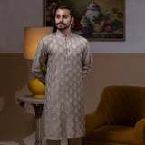Arsalan Iqbal Beige Classic Chikankari Kurta Pyjama man wearing a beige full sleeve kurta with intricate white chikankari floral embroidery, mandarin collar, and a relaxed tailored fit, styled in a warm indoor setting