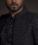 Extreme close-up of Arsalan Iqbal midnight black luxury sherwani showing intricate tonal black embroidery, sequin work, and fabric-covered buttons on a silk kurta.