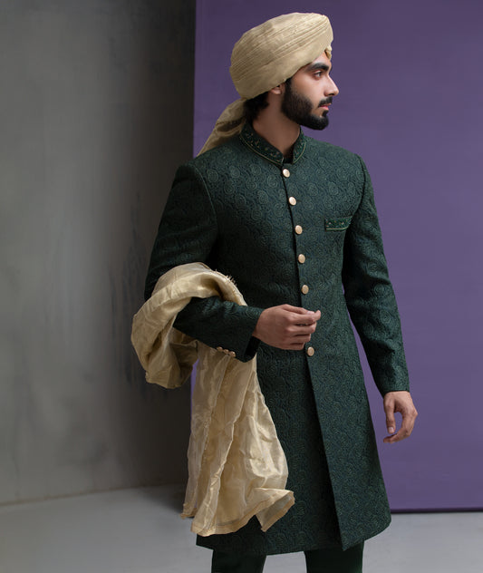 Arsalan Iqbal designer emerald green embroidered sherwani for men, featuring gold buttons and a beige silk turban with a matching dupatta.