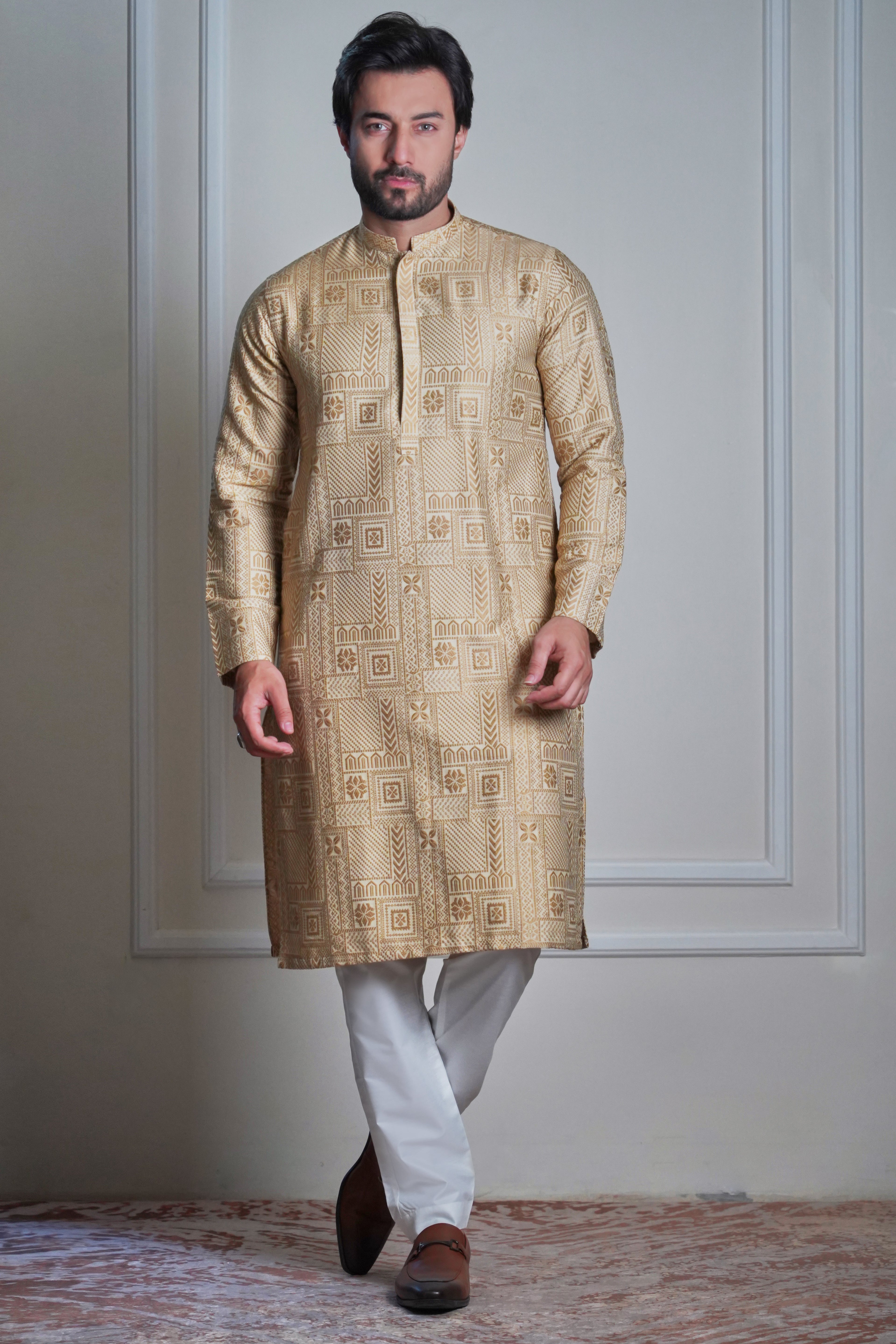 Male model wearing a gold embroidered sherwani by Arsalan Iqbal, luxury South Asian wedding groom attire