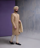 Full-length side profile of Arsalan Iqbal gold embroidered sherwani for men, paired with cream-colored trousers, black loafers, and a beige silk turban.