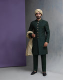 Arsalan Iqbal emerald green embroidered sherwani for men, featuring a side profile view with a beige silk turban and gold buttons