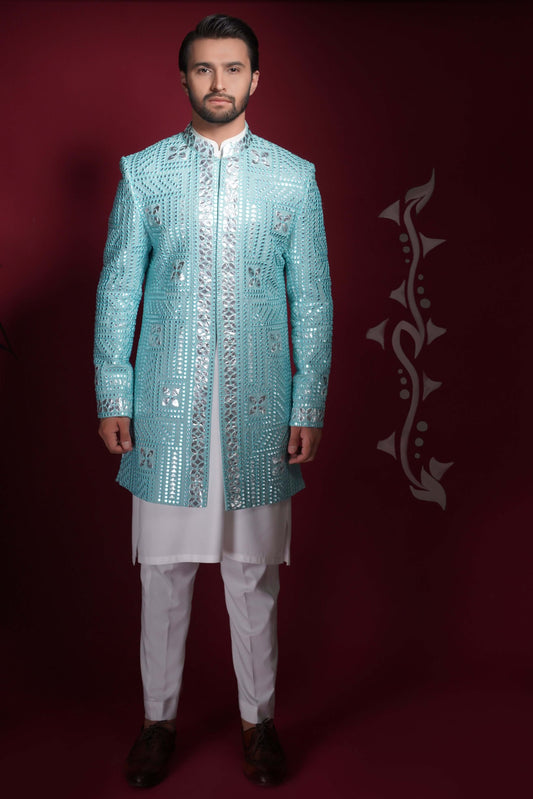 Arsalan Iqbal ice-blue prince coat heavily embellished with silver mirror-work in a geometric grid pattern, worn over a white long kurta and trousers.