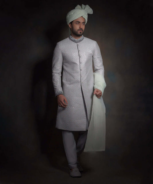 Arsalan Iqbal luxury light mint green sherwani featuring silver geometric embroidery, a dark grey embroidered mandarin collar and cuffs, styled with a matching mint turban and grey formal trousers.