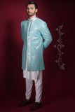 Arsalan Iqbal ice-blue prince coat with silver geometric mirror-work, featuring a mandarin collar and worn over a white long kurta and trousers.