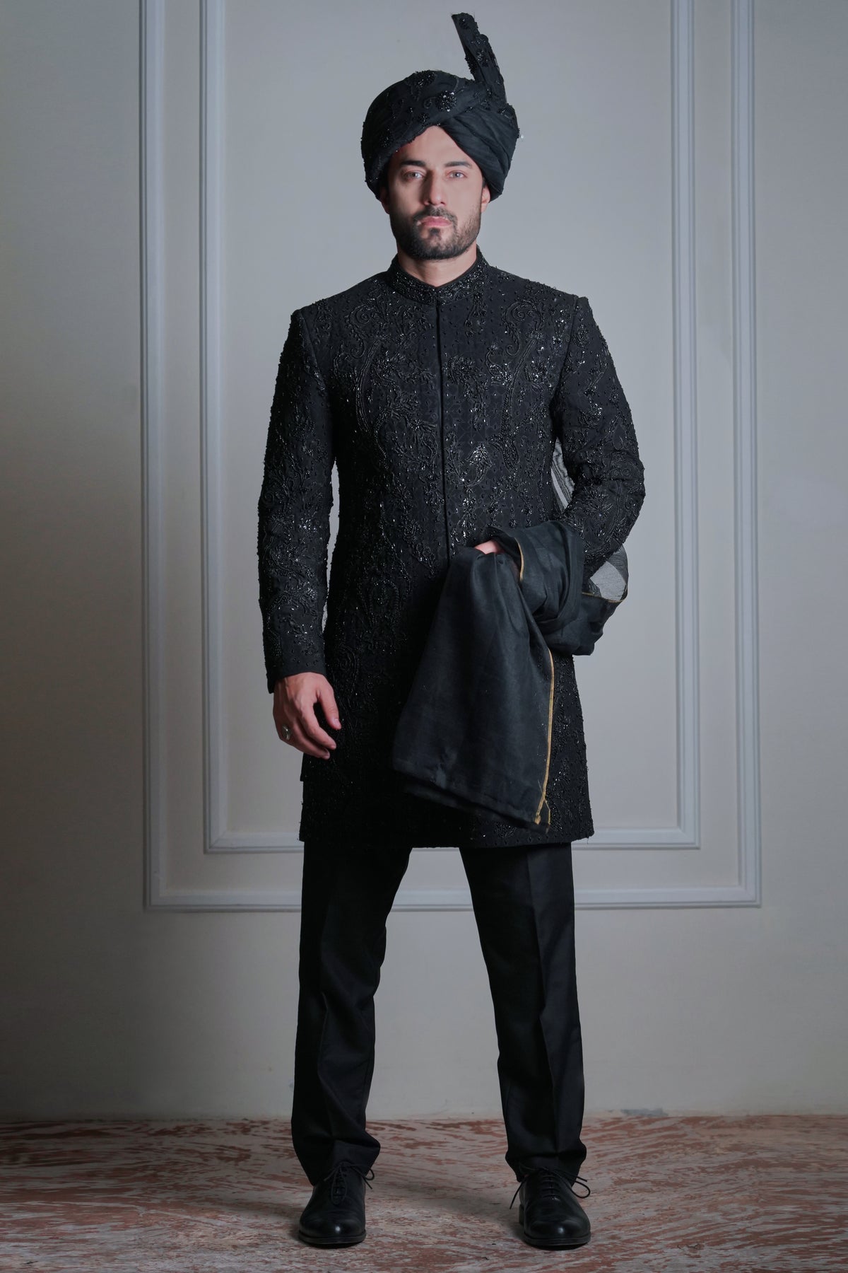 Male model wearing a black embroidered sherwani with turban by Arsalan Iqbal, luxury groom and wedding menswear