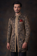 Arsalan Iqbal bronze-olive sherwani with gold ivy tilla embroidery, featuring a leaf-patterned mandarin collar and a crimson red pocket square.