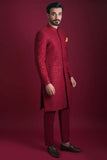 Side profile full view of Arsalan Iqbal luxury crimson red sherwani with tonal floral embroidery and silver sequins, paired with matching red trousers and a mustard silk pocket square.