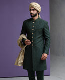 Close up shot of Arsalan Iqbal designer green sherwani featuring intricate embroidery, gold buttons, and a premium beige turban.