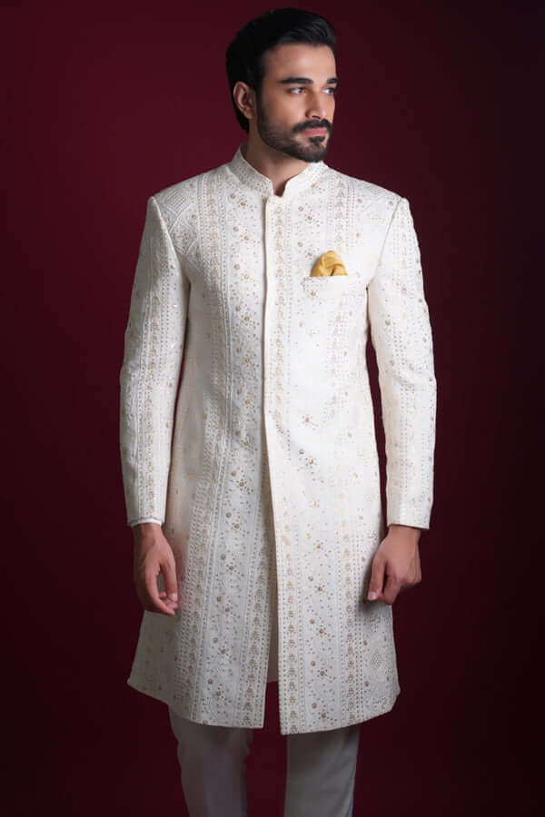 Arsalan Iqbal luxury ivory sherwani with vertical gold star embroidery and a yellow silk pocket square, featuring a mandarin collar and concealed placket.