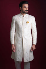 Arsalan Iqbal luxury ivory sherwani with vertical gold star embroidery and a yellow silk pocket square, featuring a mandarin collar and concealed placket.