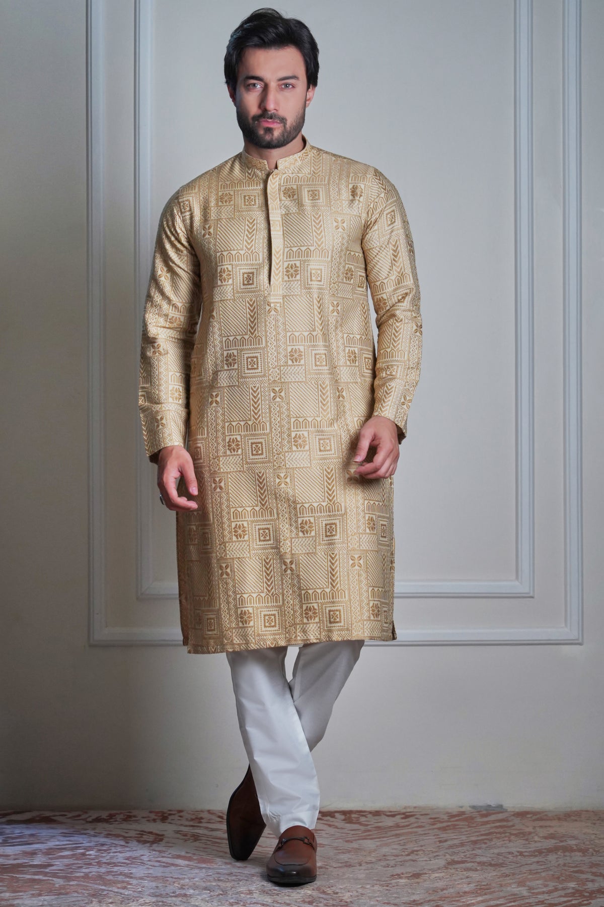 Male model wearing a gold embroidered sherwani by Arsalan Iqbal, luxury South Asian wedding groom attire