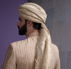 Close-up back view of Arsalan Iqbal gold embroidered sherwani, showing the intricate hand-embroidery on the shoulder and the detailed texture of the beige silk turban.