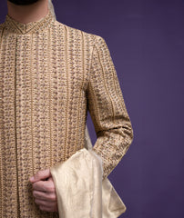 Extreme close-up of Arsalan Iqbal gold sherwani showing intricate vertical hand-embroidery, sequin work, and premium fabric texture with a silk dupatta.