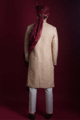 Back view of Arsalan Iqbal luxury cream and gold sherwani with continuous vertical chevron embroidery, featuring a maroon embroidered turban and a long-draped maroon shawl over the shoulder.
