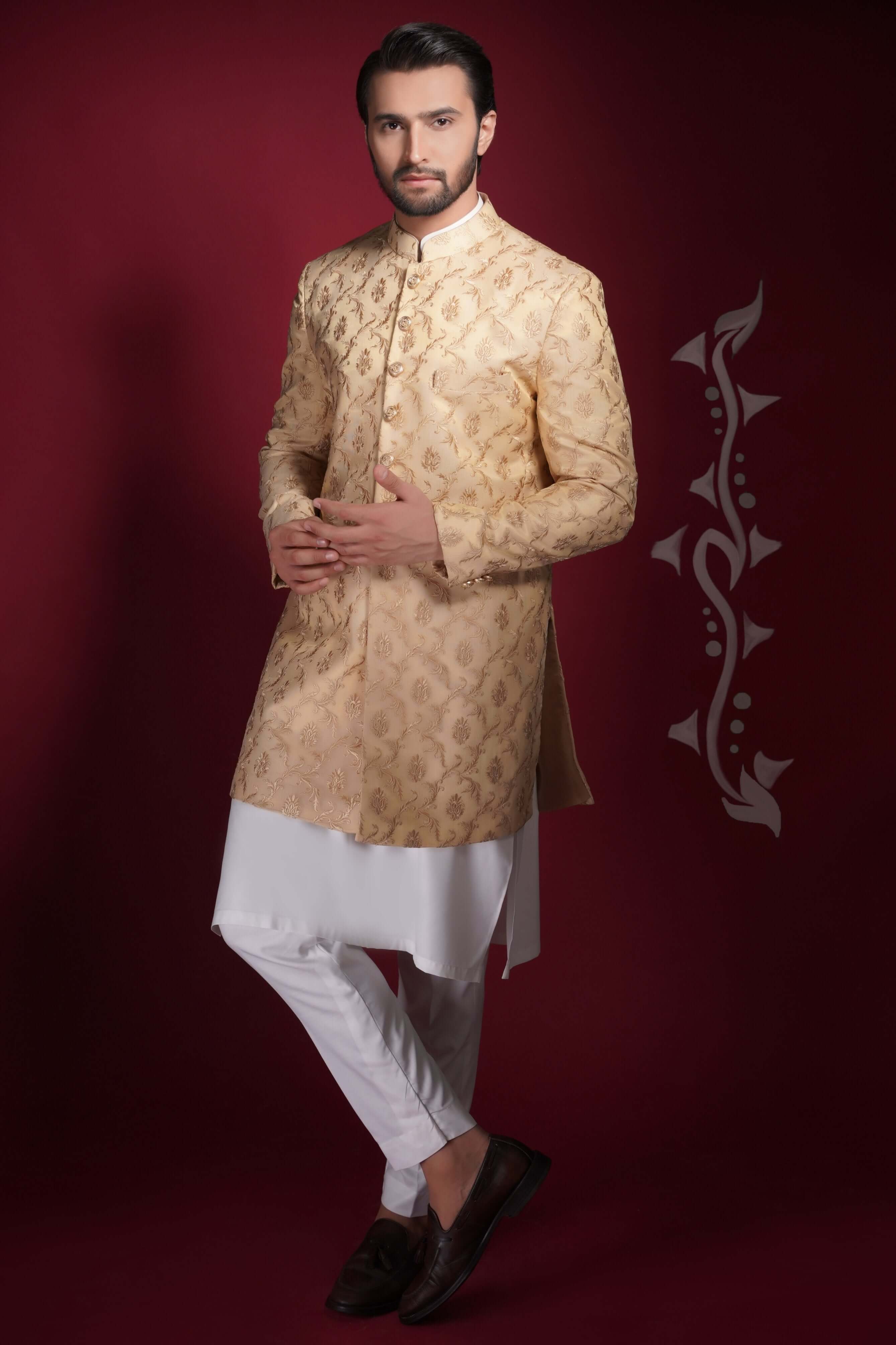 Arsalan Iqbal champagne gold prince coat with damask-style floral embroidery, paired with a long white tunic kurta and slim-fit trousers.