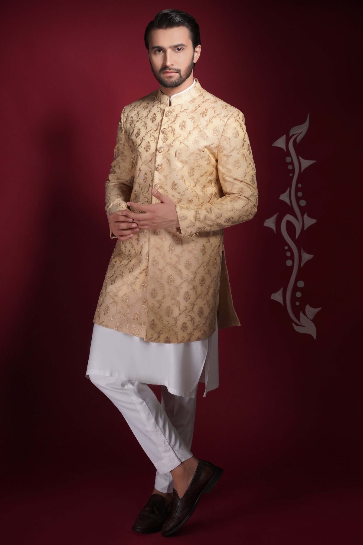 Arsalan Iqbal champagne gold prince coat with damask-style floral embroidery, paired with a long white tunic kurta and slim-fit trousers.