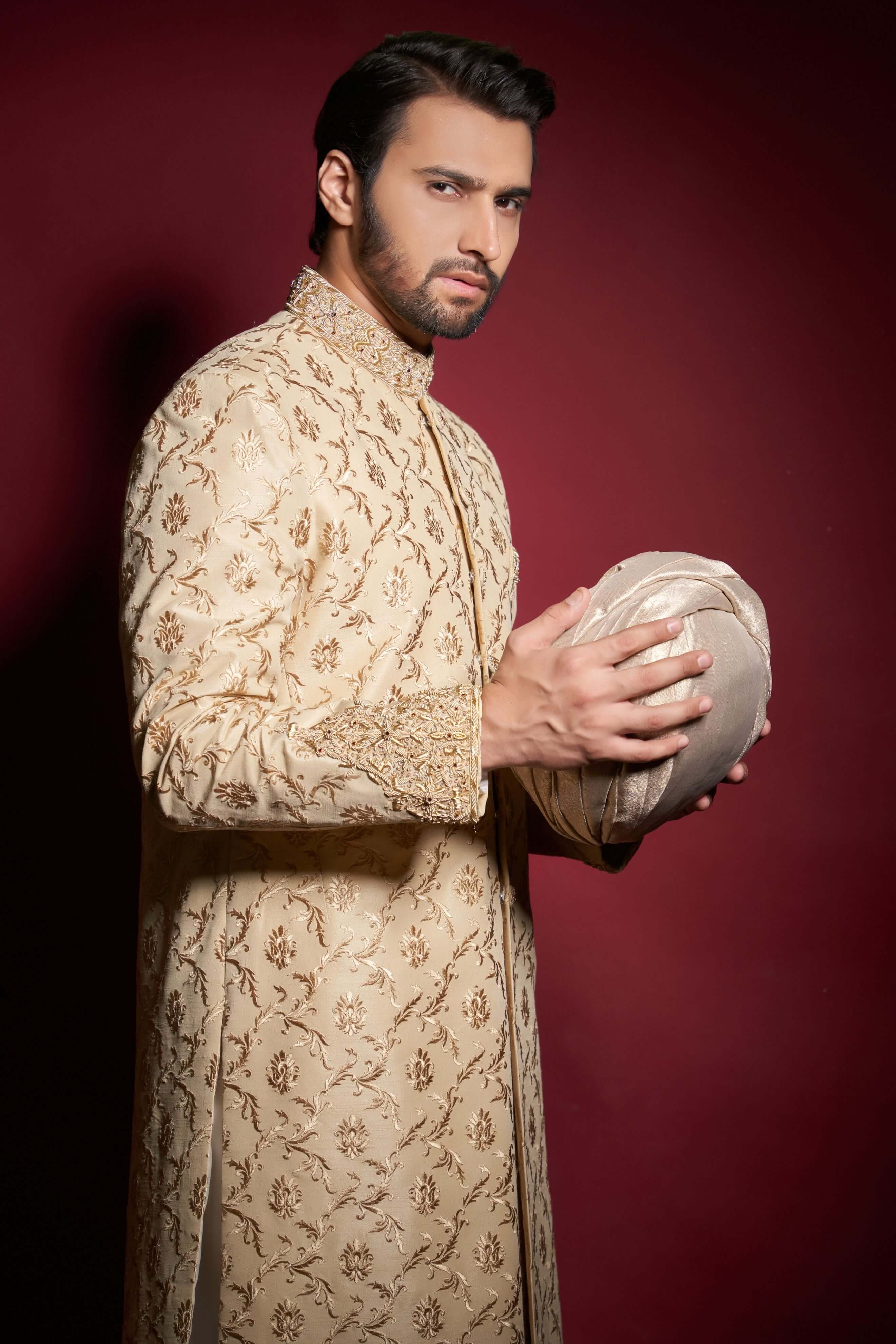 Side-profile portrait of Arsalan Iqbal champagne gold silk sherwani featuring intricate floral ivy tilla embroidery and a heavily embellished mandarin collar.