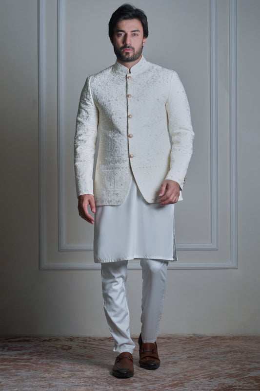 Model wearing an ivory embroidered sherwani with white kurta pajama and brown leather loafers by Arsalan Iqbal