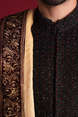 Extreme close-up of Arsalan Iqbal luxury black sherwani featuring a diamond-grid of black sequins and red beads, paired with a maroon velvet shawl showcasing a rich golden tilla floral border.