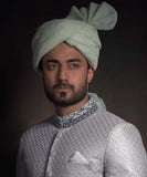 Portrait of Arsalan Iqbal luxury mint green sherwani with silver geometric embroidery, featuring a charcoal grey embroidered collar and a matching mint green turban.