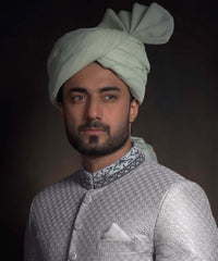 Portrait of Arsalan Iqbal luxury mint green sherwani with silver geometric embroidery, featuring a charcoal grey embroidered collar and a matching mint green turban.