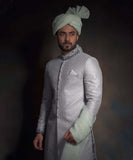 Arsalan Iqbal light mint green luxury sherwani with silver geometric patterns, featuring a charcoal grey embroidered mandarin collar, a white pocket square, and a matching mint turban.