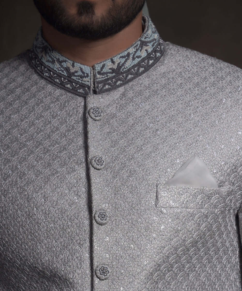 Close-up of Arsalan Iqbal mint green sherwani with silver geometric embroidery, featuring a charcoal grey mandarin collar with intricate silver threadwork and matching embroidered fabric buttons.