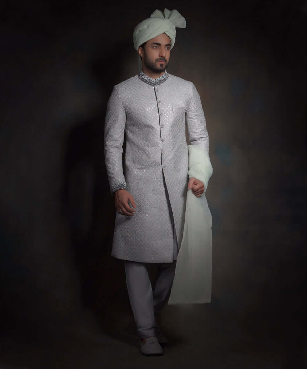 Arsalan Iqbal luxury light mint green sherwani featuring silver geometric embroidery, a dark grey embroidered mandarin collar and cuffs, styled with a matching mint turban and grey formal trousers.
