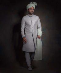 Arsalan Iqbal luxury light mint green sherwani featuring silver geometric embroidery, a dark grey embroidered mandarin collar and cuffs, styled with a matching mint turban and grey formal trousers.