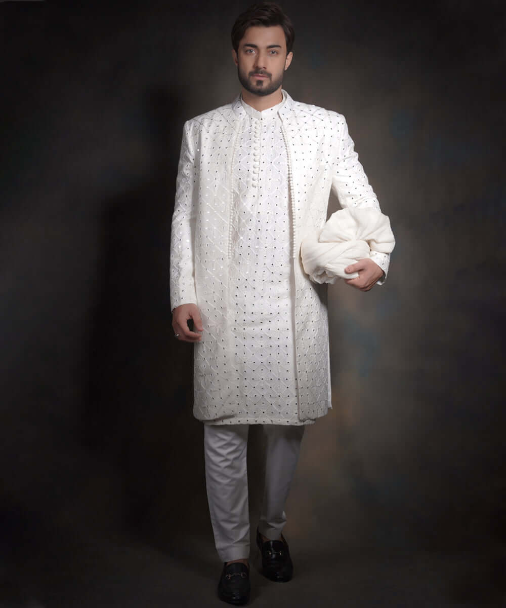 Arsalan Iqbal snow white luxury sherwani for men, featuring intricate geometric mirror-work and embroidery, styled with a matching white kurta, formal trousers, and black loafers.