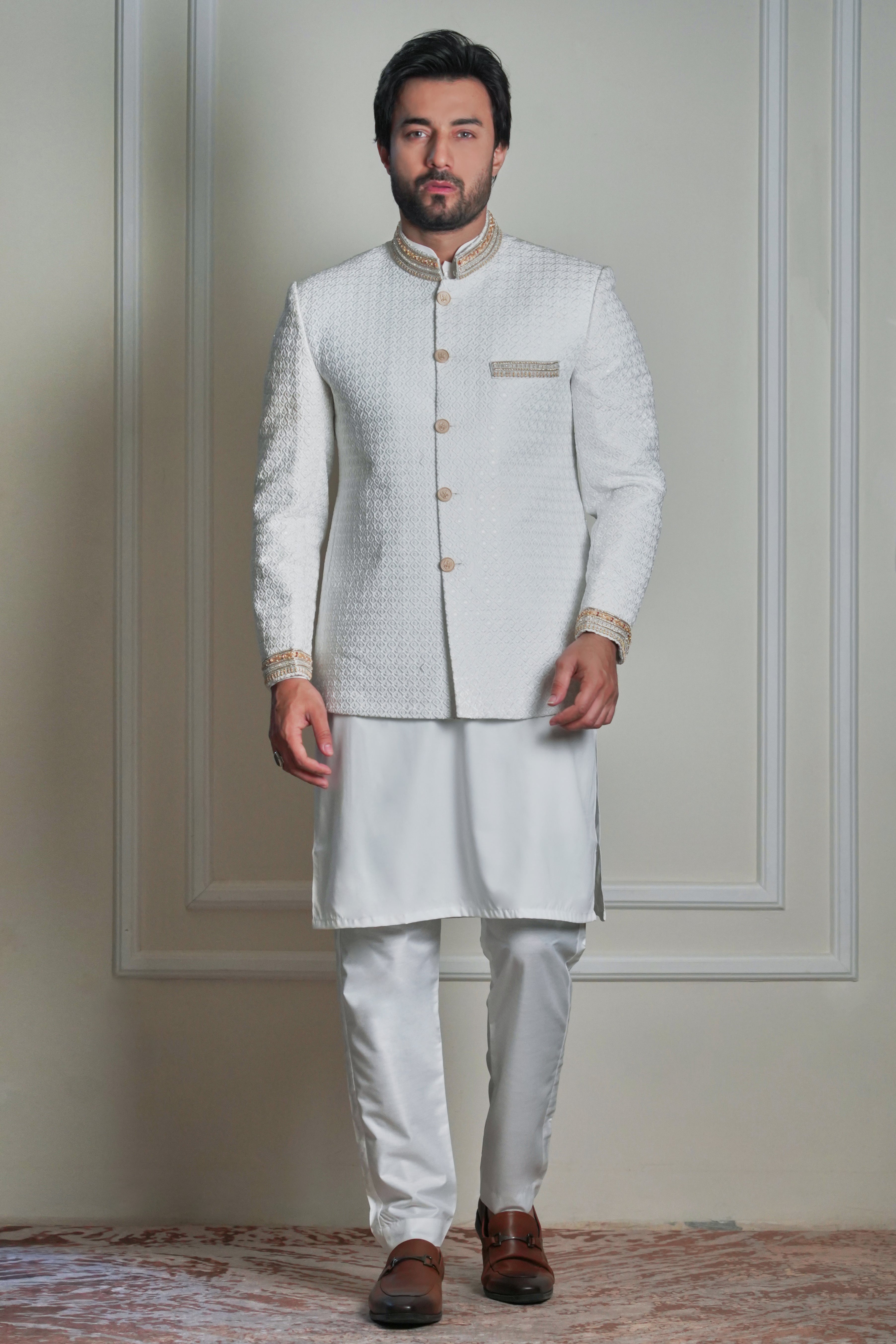 Men’s ivory jacquard prince coat with gold detailing, styled with matching kurta and churidar, formal wedding wear look.