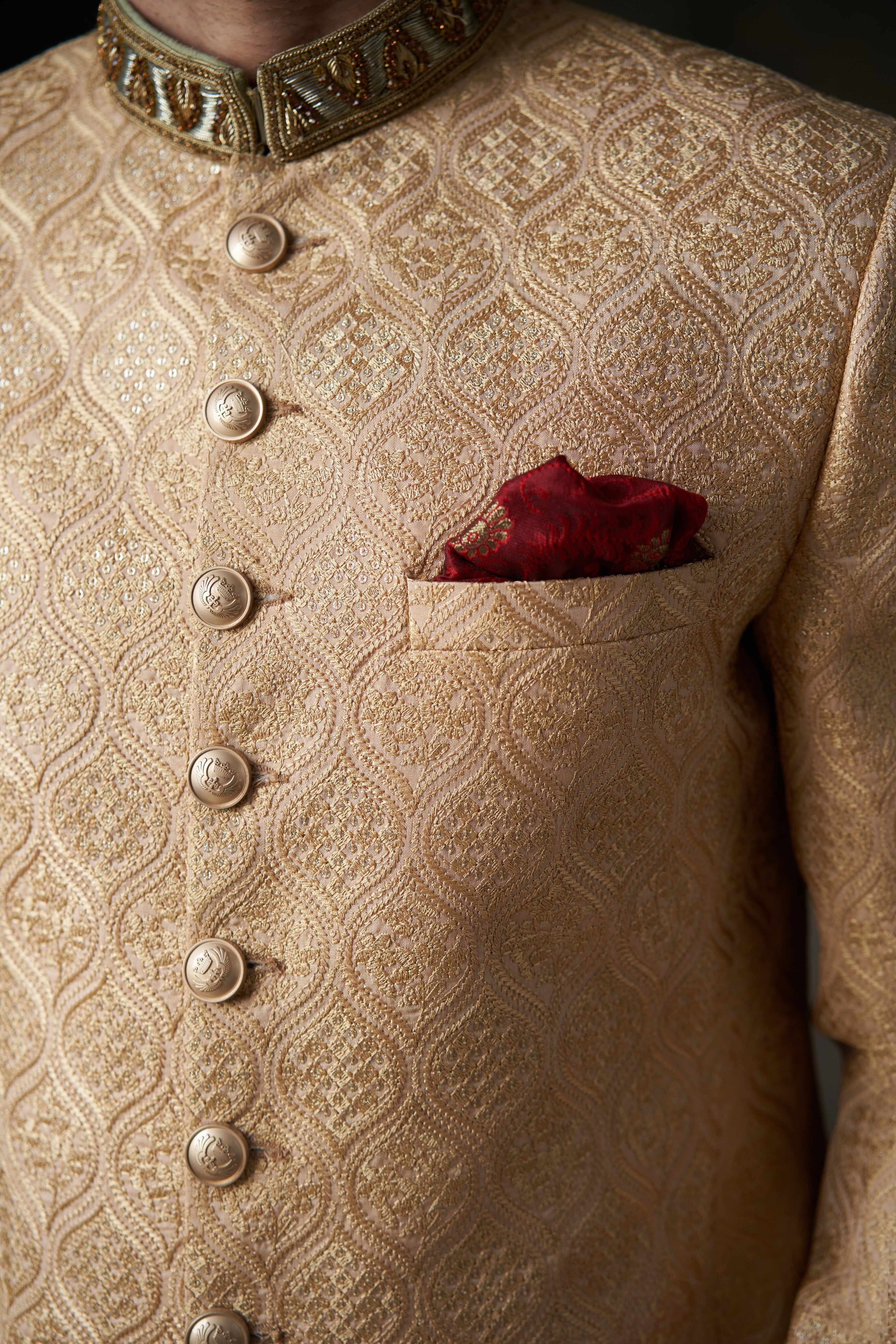 Arsalan Iqbal gold silk sherwani with an ogee-patterned damask weave, featuring embossed metal buttons and a ruby-red silk pocket square.