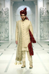Medium portrait of a man wearing a black Arsalan Iqbal sherwani featuring gold embroidery on the cuffs and a maroon brocade turban.