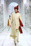 Full-length studio shot of a man in an Arsalan Iqbal black textured sherwani with a maroon pocket square, matching turban, and white trousers.