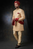 Arsalan Iqbal gold silk sherwani with damask embroidery, paired with a ruby-red velvet turban, shawl, and cream trousers.