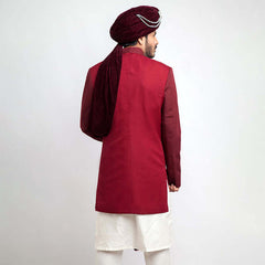 Back view of an Arsalan Iqbal teal paisley jamawar sherwani highlighting the drape of a white brocade shawl and the tailored fit.