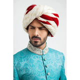 Close-up headshot of an Arsalan Iqbal teal paisley sherwani highlighting the silver embroidered mandarin collar and a white brocade turban with maroon velvet accents.
